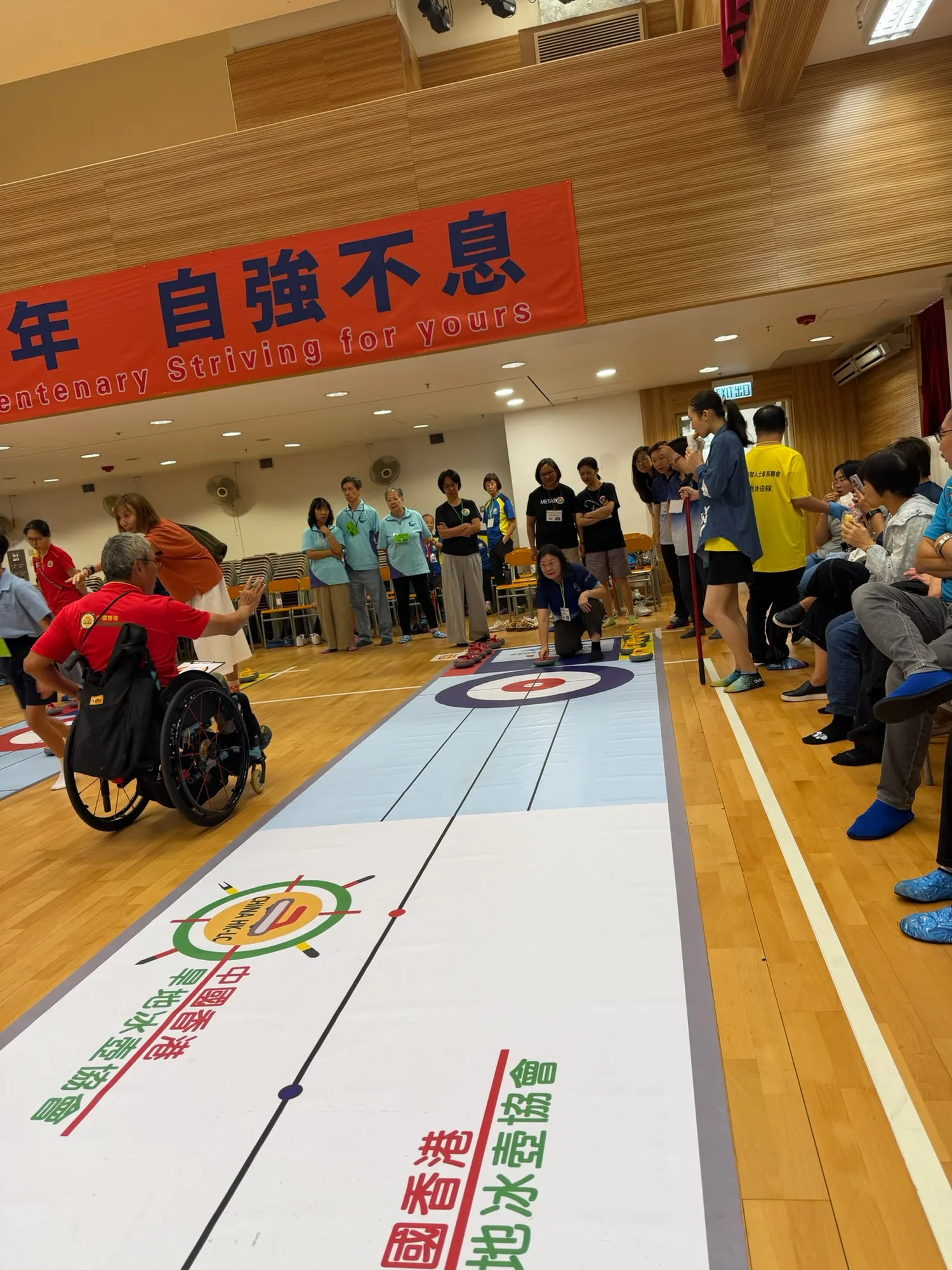 輪椅參加者與場邊人士在賽道旁觀看活動