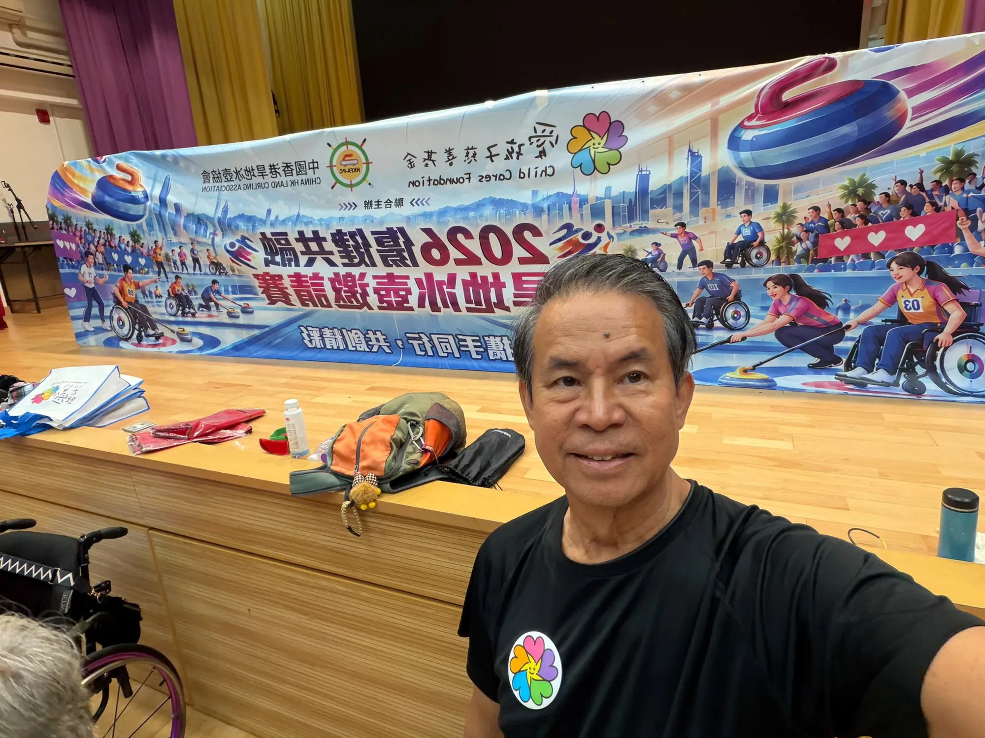 一名工作人員在活動橫額及賽道前自拍