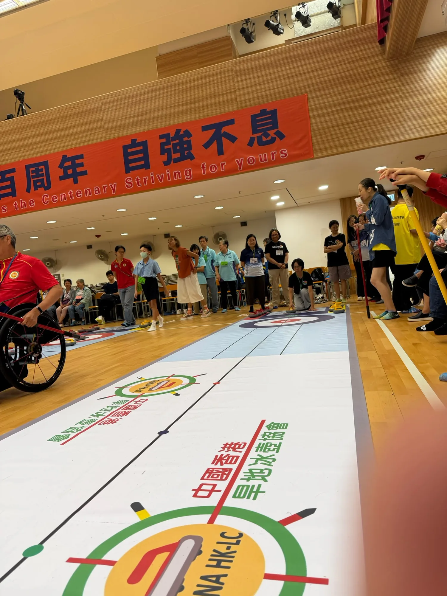 輪椅參加者與其他人士在多條賽道旁觀看比賽