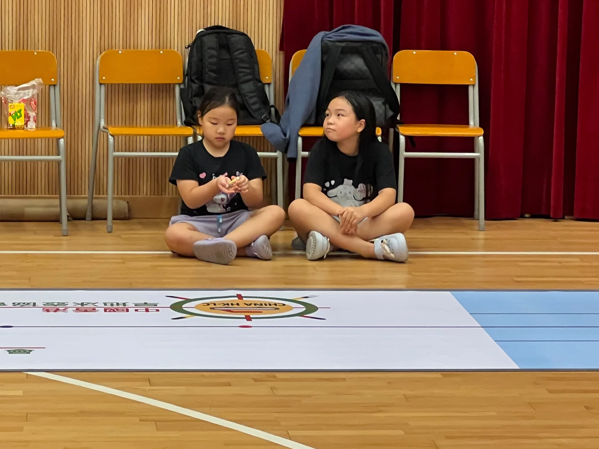 兩名參加者坐在賽道起點準備投球